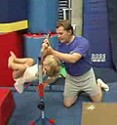 Tomas helps a small girl just starting in gymnastics
